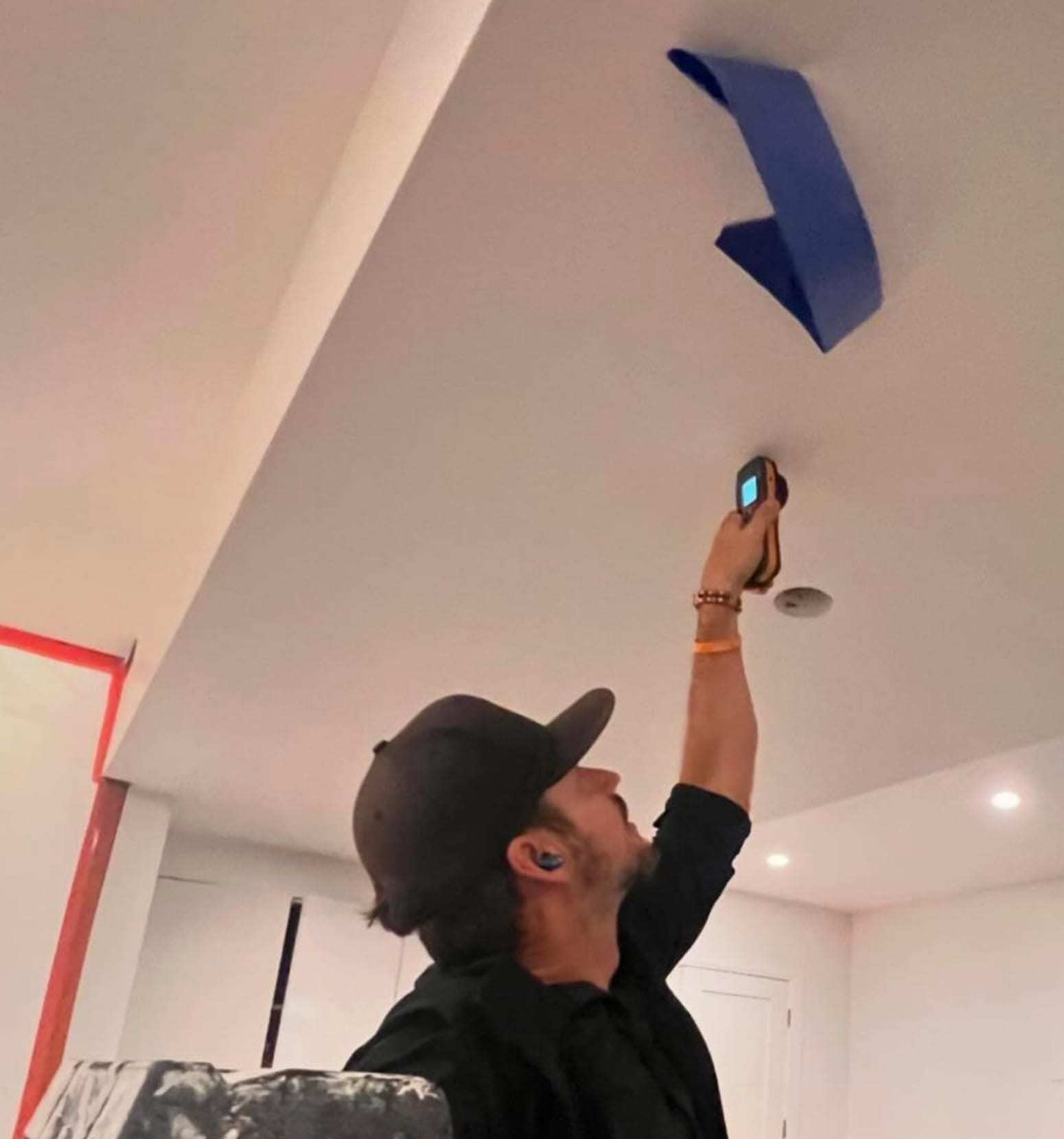 Technician taking a temperature reading at a ceiling